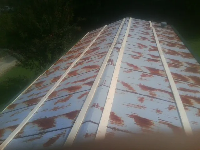Rusted metal roof panels with new wood purlins before replacement — Storm Damage Roof Repair in Howell by Roofing Brothers